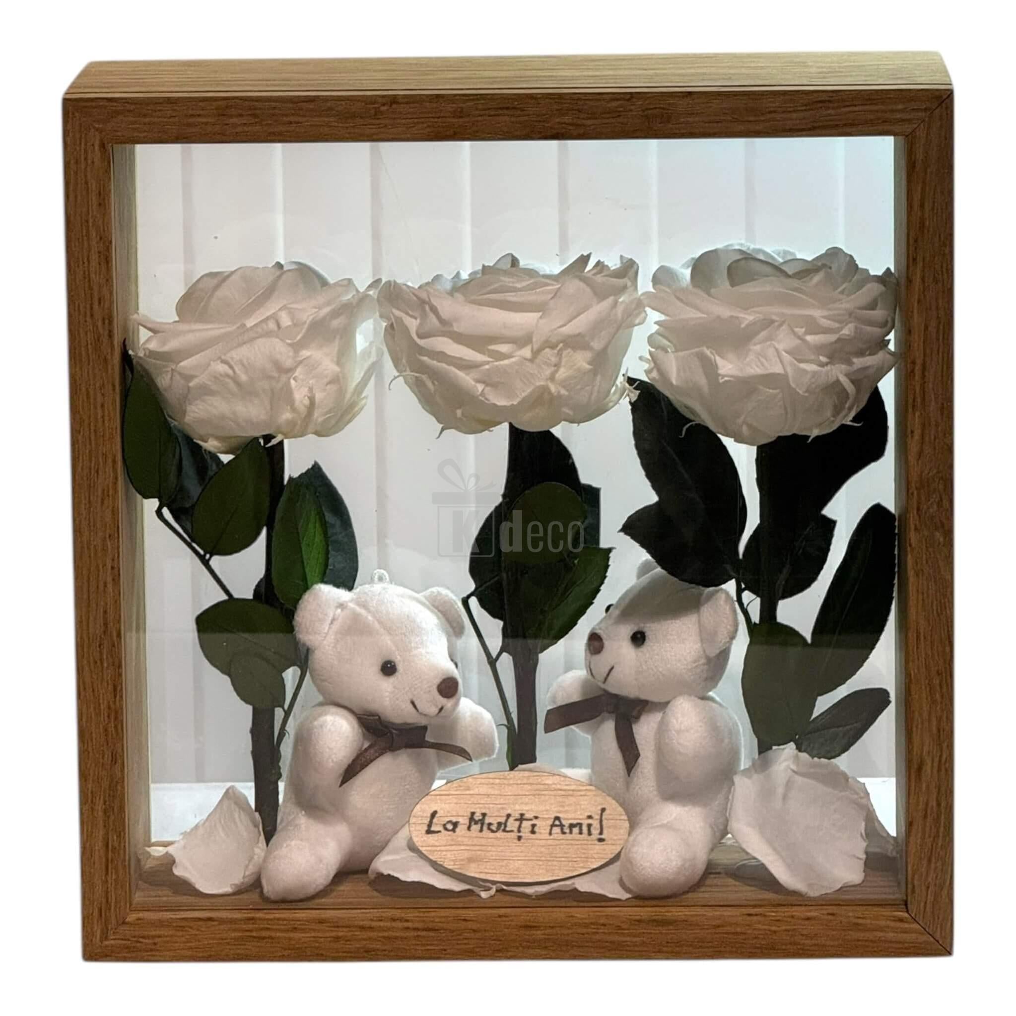 Aranjament cu 3 trandafiri criogenați albi și 2 ursuleți de plus, în ramă de lemn, cu mesaj 'La Mulți Ani'.