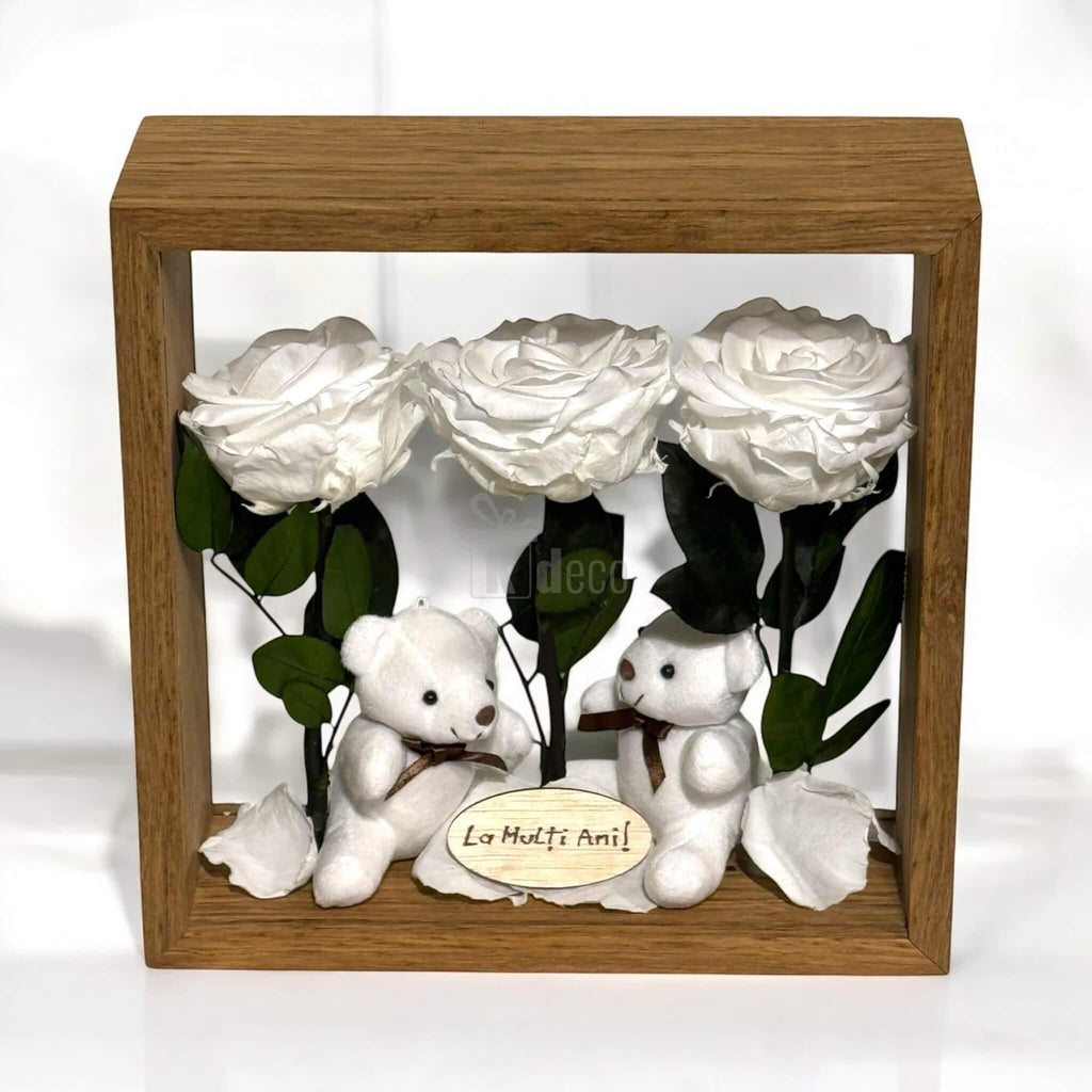 Decor elegant cu trandafiri criogenați albi și ursuleți de plus, ideal pentru cadou aniversar, în ramă pătrată din lemn și plexiglas.
