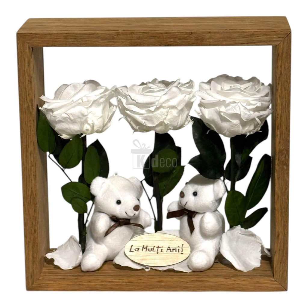Aranjament de masă cu 3 trandafiri criogenați albi, 2 ursuleți de plus și mesaj personalizat 'La Mulți Ani' în ramă din plexiglas 27x27cm.