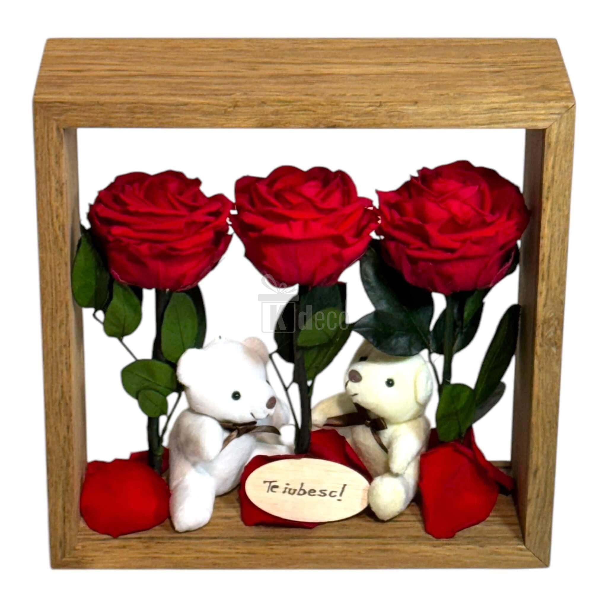 Aranjament floral cu trandafiri criogenați roșii și ursuleți de plus, în ramă de lemn, perfect pentru decor romantic sau cadou special.