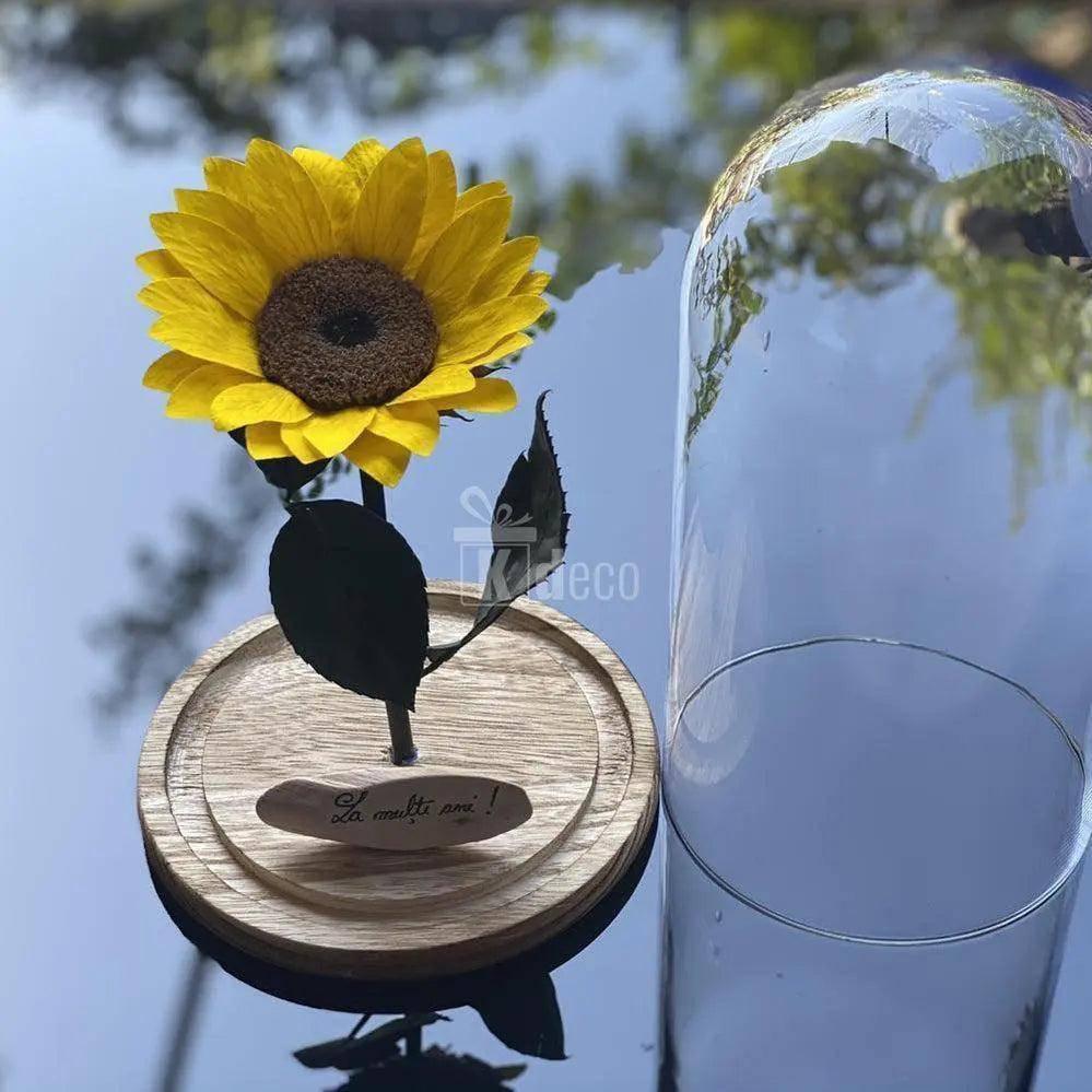 Floarea Soarelui Criogenata în cupolă de sticlă pe suport din lemn, cu mesaj personalizat 'La mulți ani!', ideală ca decor sau cadou elegant.